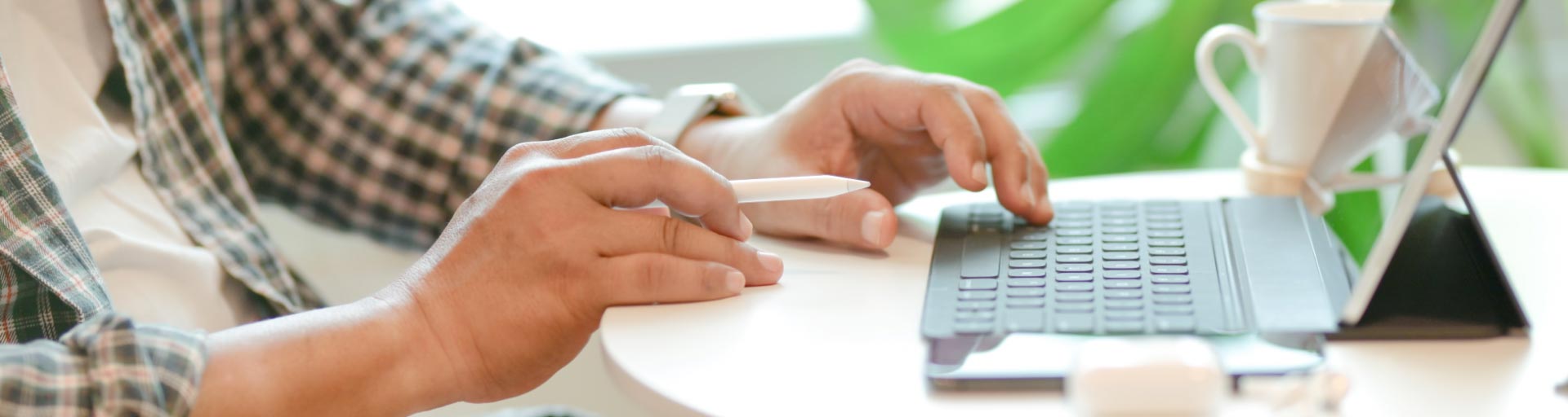 Employee at desk with digital pen and laptop