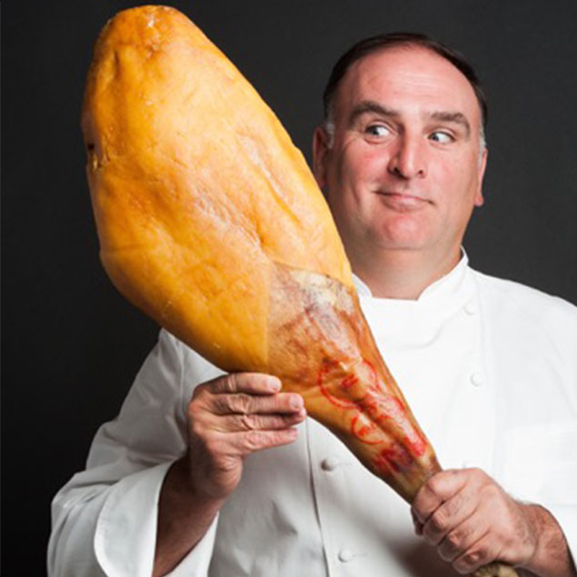 jose andres holding a large meat stick