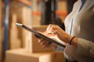 warehouse manager looking through analytics from their phone for oracle warehouse management software alternatives
