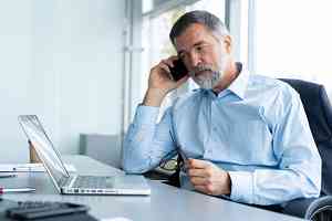 senior businessman speaking with warehouse manager on the phone