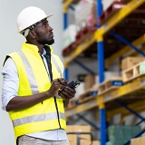 warehouse manager looking through their shelving to monitor inventory