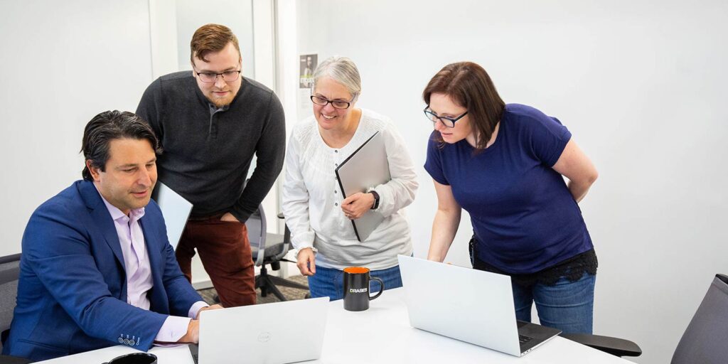 Orases team looking at laptop