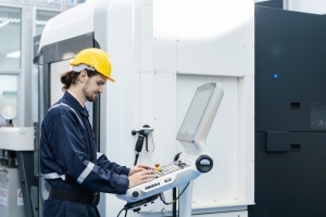 factory assembly worker using condition monitoring software to review the status of machinery