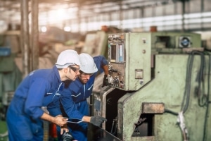 factory workers using condition monitoring software to create maintenance repair orders