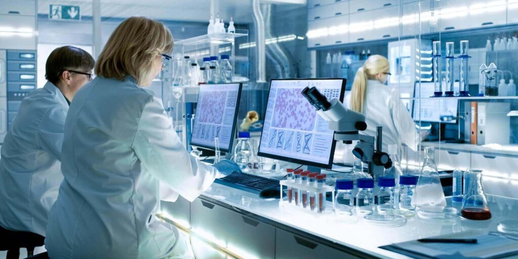 female and male scientists working on their computers in big modern laboratory