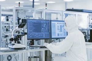 man wearing ppe working on lab computer