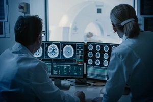 doctor and radiologist discuss diagnosis while watching procedure and monitors showing brain scans results