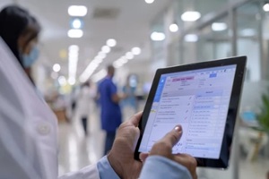 medical professional is focused on a tablet displaying medical claims software