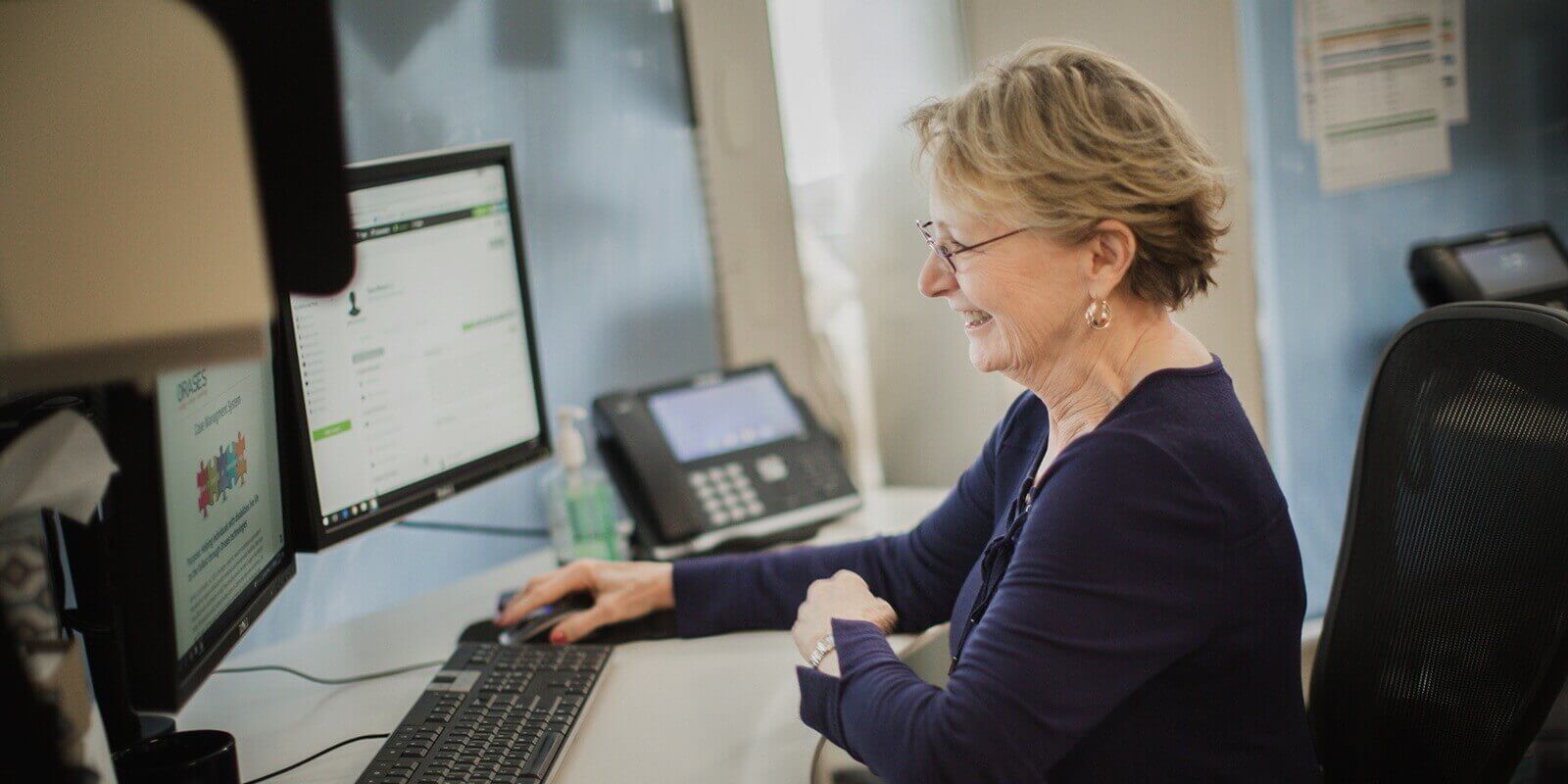 aged women looking at computer screen and smiling