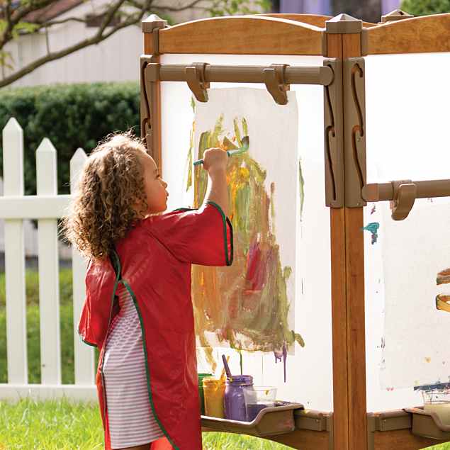 Child painting outside in community