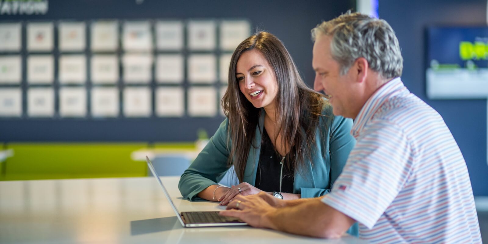 two collegues discussing important project points on a laptop