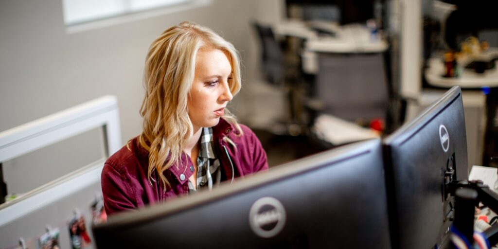 female employee working on multi-screen systems