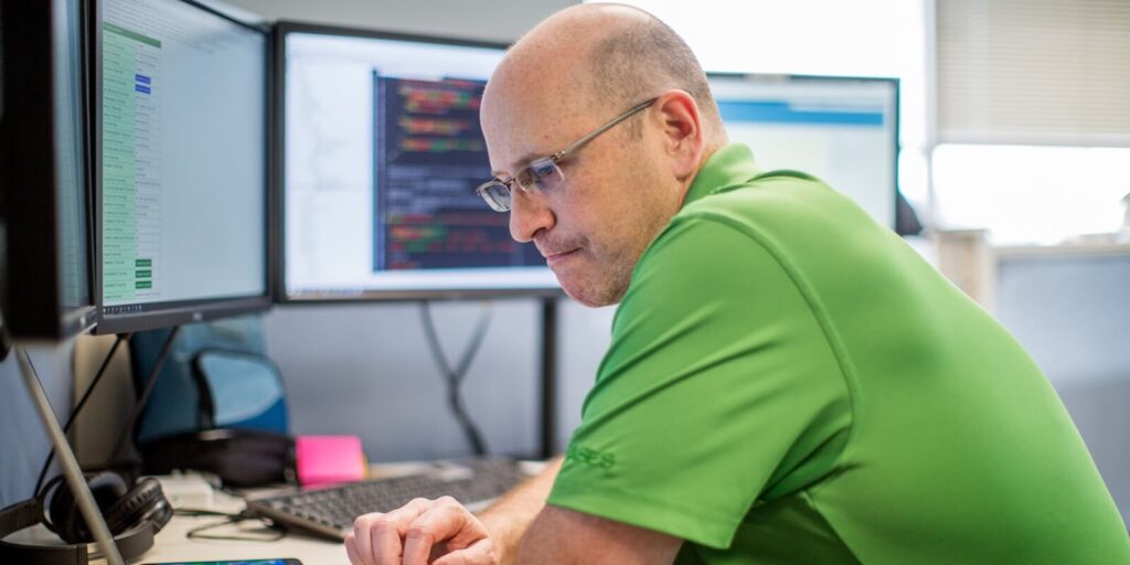 employee in green tshirt focused on ai data strategy