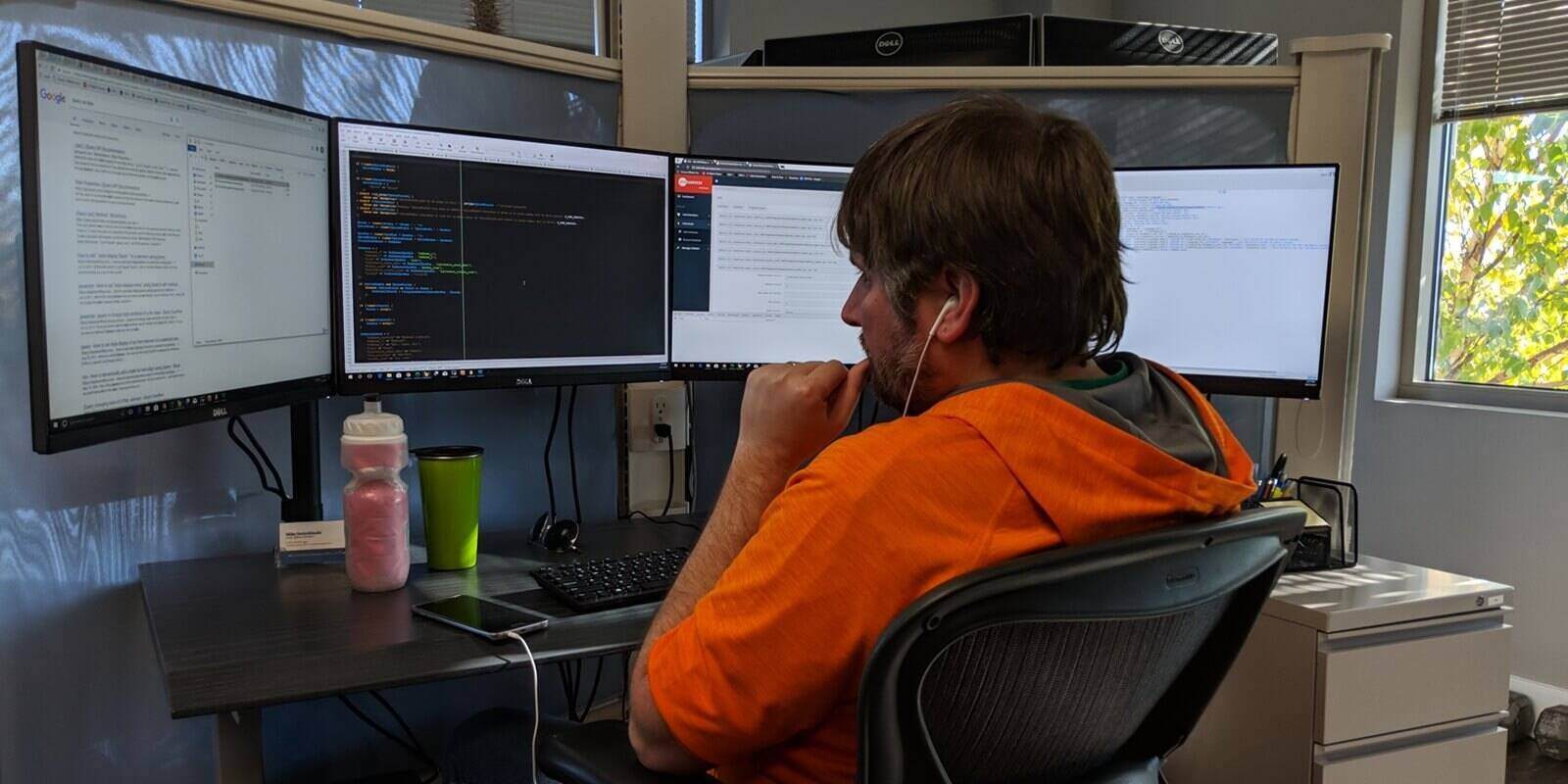 dedicated employee working on data strategy on 4 screen system