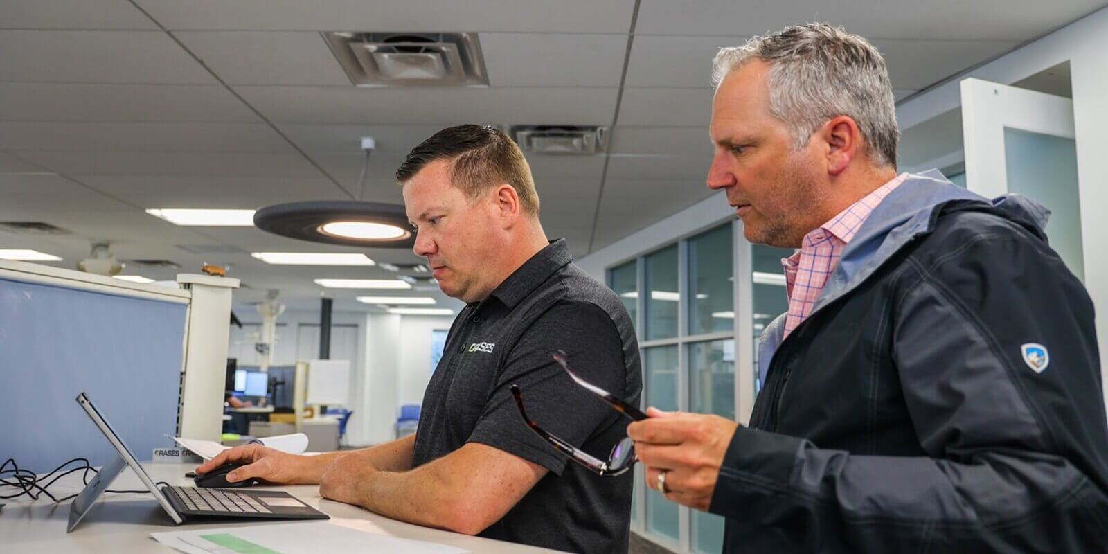 professionals engaged in a focused discussion at a modern office workstation